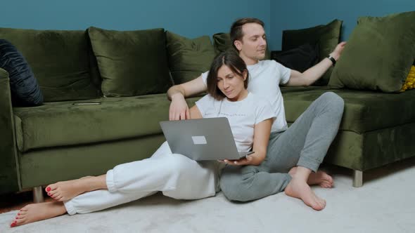 Woman That is Working at the Computer Receiving a Bouquet of Yellow Tulips From Her Husband