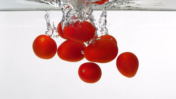 Slo-motion cherry tomatoes through water
