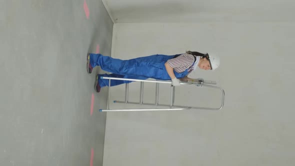 Repairwoman with Ladder Inspects Room