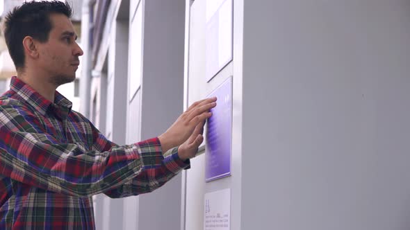 Blind Guy on the Street Reading a Braille Font on a Building Sign