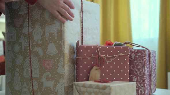 Women Hands Adjust Gift Boxes on the Table