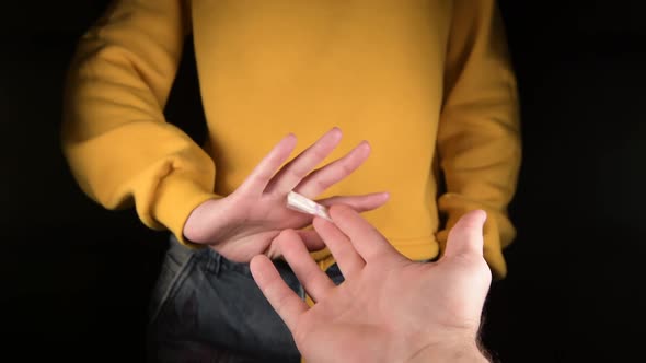 hand extends a dose of a drug and the girl refuses. Close-up without a face