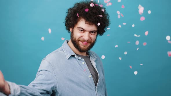 Flirty Man with Kinky Hair Scatters Bright Pink Confetti