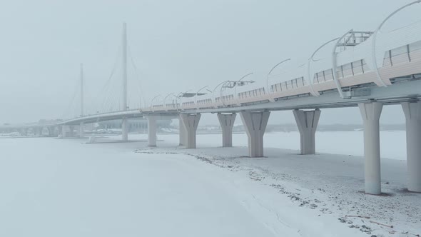 The Drone Flies Along the Cablestayed Bridge in a Snow Storm Highway Blizzard