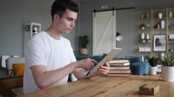 Online Shopping on Tablet By Man Sitting at Wrok