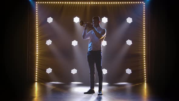 Solo Performance of a Professional Trumpeter in the Studio Against the Backdrop of Neon Lights. Slow