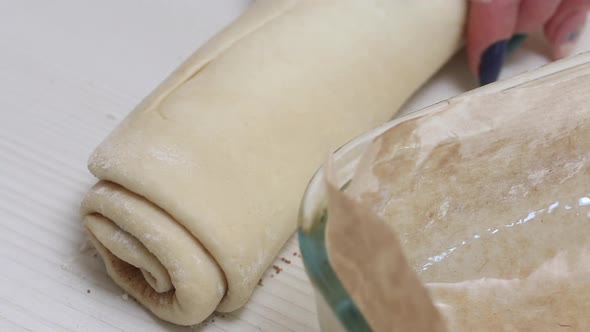 Woman Cuts Dough With Cinnamon For Baking Cinnabons. Close Up Shot.