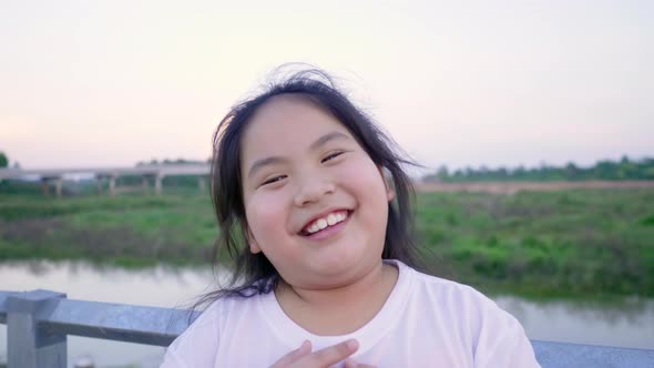 Close up of Asian girl speaking by video call among a farm