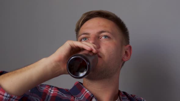 A Young Man Drinking Beer While Sitting on the Couch