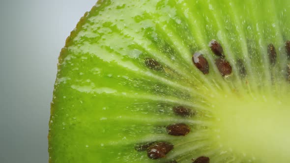 Macro of kiwi cut in half with seeds and juices shining