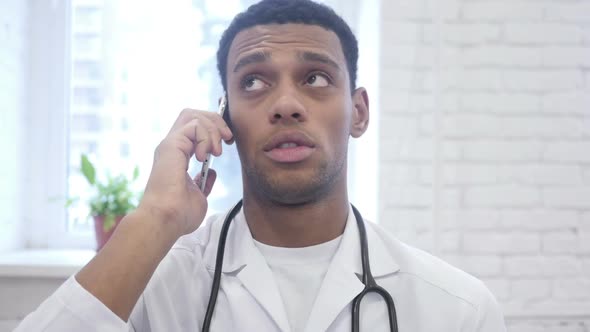 African American Doctor Talking on Smartphone in Hospital