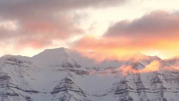 Clouds passing by mountain peak during sunrise