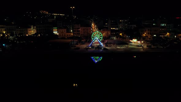 Aerial view of small amusement park with lights at night in Greece.