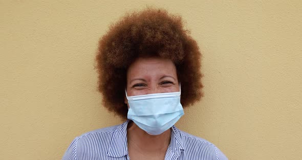 Close up of mature african woman wearing face mask for coronavirus outbreak