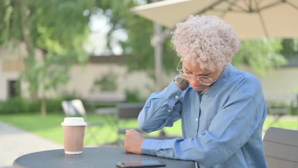 Young African Woman with Coffee Having Neck Pain in Outdoor Cafe