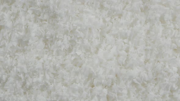 close up of a coconut and grounded coconut flakes