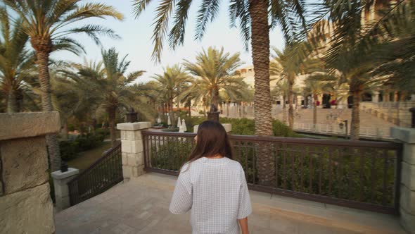 Woman Walking Down the Stairs in Luxury Tropical Resort with Pool in Dubai