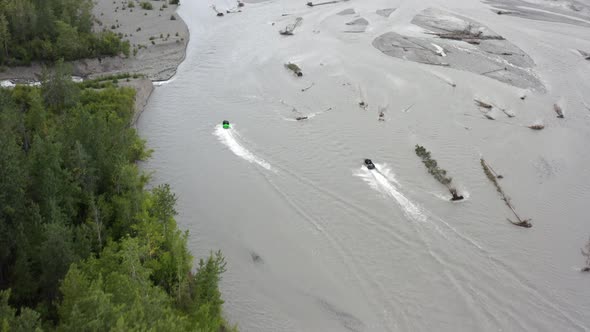 Aerial View of Speedboats Moving Fast on Glacial River in a Wilderness of Alaska USA. Tilt Up Drone