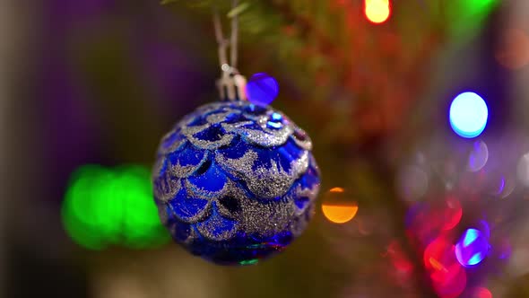 Christmas Tree Decorated with Blue Glass Ball on Christmas Spruce Branch on Background Bokeh of