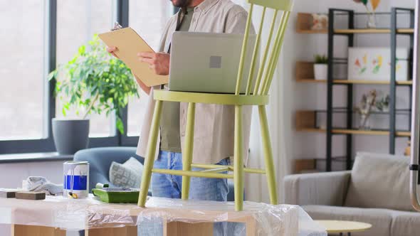 Man with Laptop Preparing Old Chair for Renovation