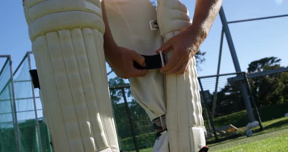 Cricket player tying his batting pads during a practice session