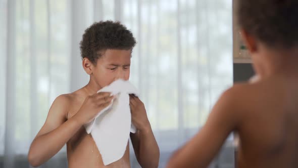 Little handsome boy wiping himself after taking shower, morning procedures