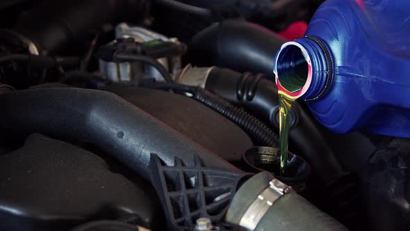 New Engine Oil Is Pouring Into The Car Engine At Workshop 4