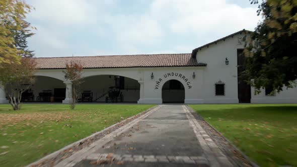 Dolly in with boom up of the main facade with the name on the front arch of the Undurraga vineyard,