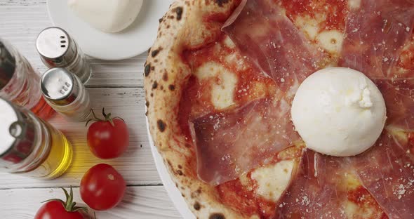 Rotating Prosciutto Pizza with Cheese on White Background