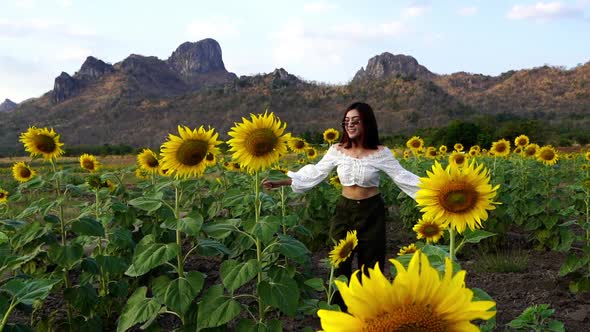 slow-motion of cheerful woman walking and enjoying with sunflower field