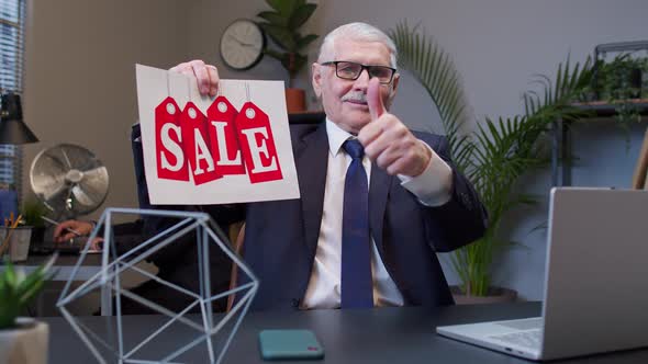 Senior Business Manager Showing Black Friday Sale Word Advertisement Inscriptions Banner in Office