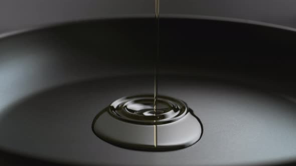 Pouring oil over fry pan. Slow Motion. alt