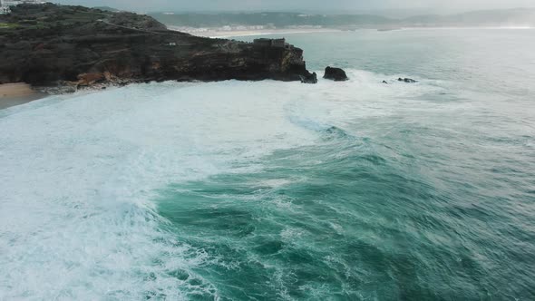 Lighthouse on Steep Cliff Near Ocean on Rainy Day Aerial