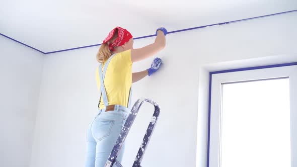 Repair of the Apartment - Professional Painter Paints the Walls with White Paint Roller