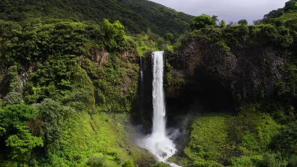 Aerial view, flying away from a large, magnificent waterfall