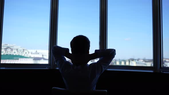 Silhouette of Woman Doing Stretching at Window