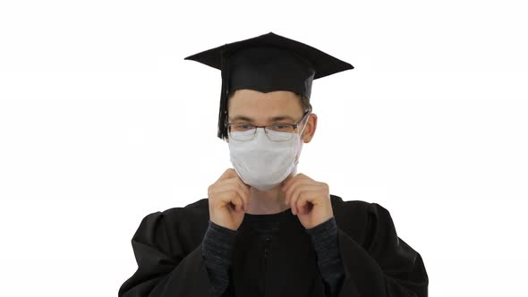 Student in Gaduation Gown and Face Mask Stumbling on White Background