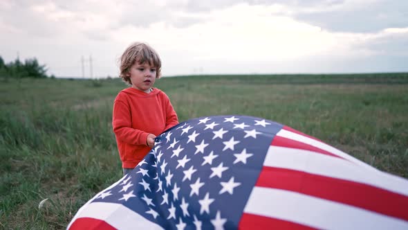 Handsome Boy  American Patriot Child Stands with Waving National Flag on Nature