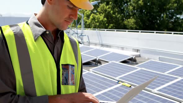 Male worker using laptop at solar station 4k