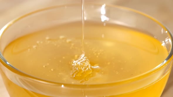 Using Spoon for Honey in Bowl, Flowing Down, Close Up, Slow Motion