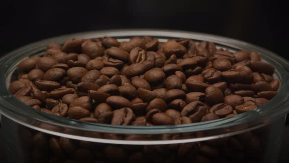 Slow Optical Zoom Out From a Glass Plate Filled with Aromatic Roasted Coffee Beans in a Dark Black