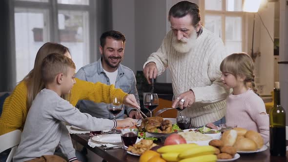 Respected Senior Grandfather Carving Traditional Roast Turkey 