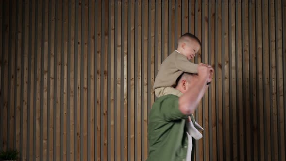 Father Holds Son Hands Spinning with Boy on Shoulders