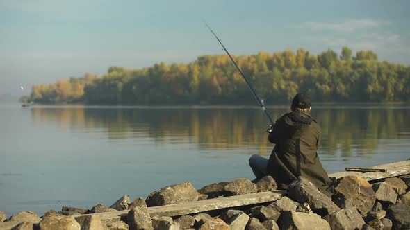 Professional Fisherman Fishing on River Bank