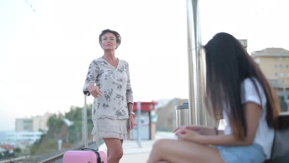 Mature Tourist Woman Waiting At The Train Station With Young Asian Woman