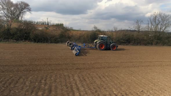 A Farmer Rolling Fields in Preparation for Spring Drilling