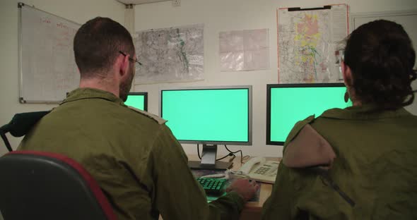 Israeli soldiers in a military command and control room looking at screens