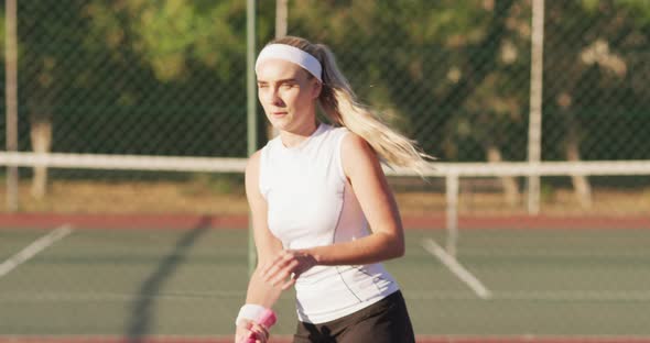 Video of focused caucasian female tennis player holding racket and hitting ball