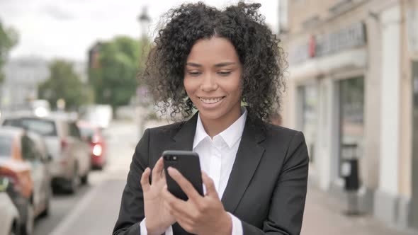 African Businesswoman Using Smartphone Standing Outdoor