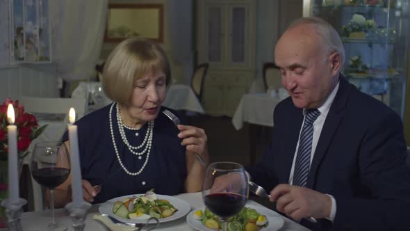 Elderly Couple Enjoying Salad in Restaurant